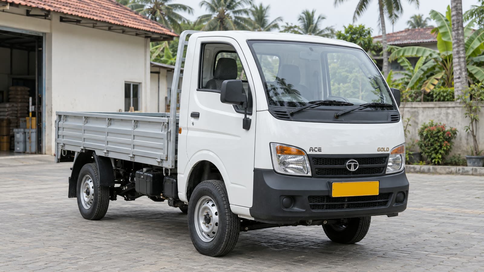 A white Tata Ace Gold mini truck parked outside a Kerala shopfront in daylight